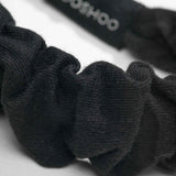 Close-up of super soft black organic cotton fabric headband with 'kooshoo' branding on a white background
#color_black
