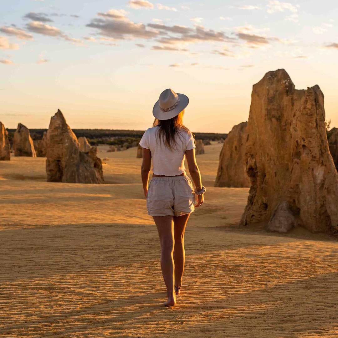 woman walking through the desert with blush walnut scrunchie on her wrist