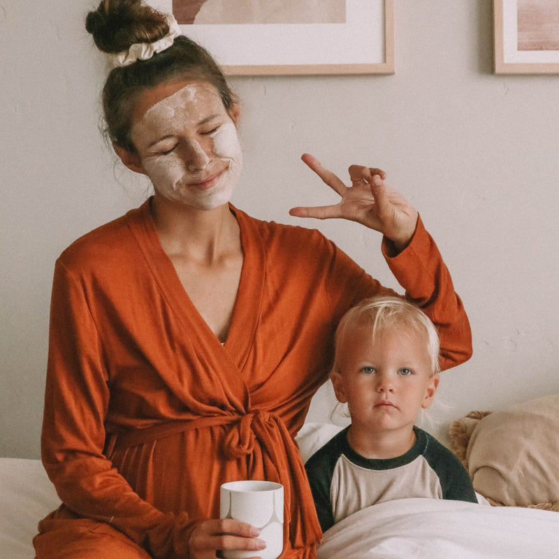 KOOSHOO scrunchies with mother and son, morning routine. Comfortable bath robe and soft organic cotton scrunchie in high messy bun #color_cappuccino