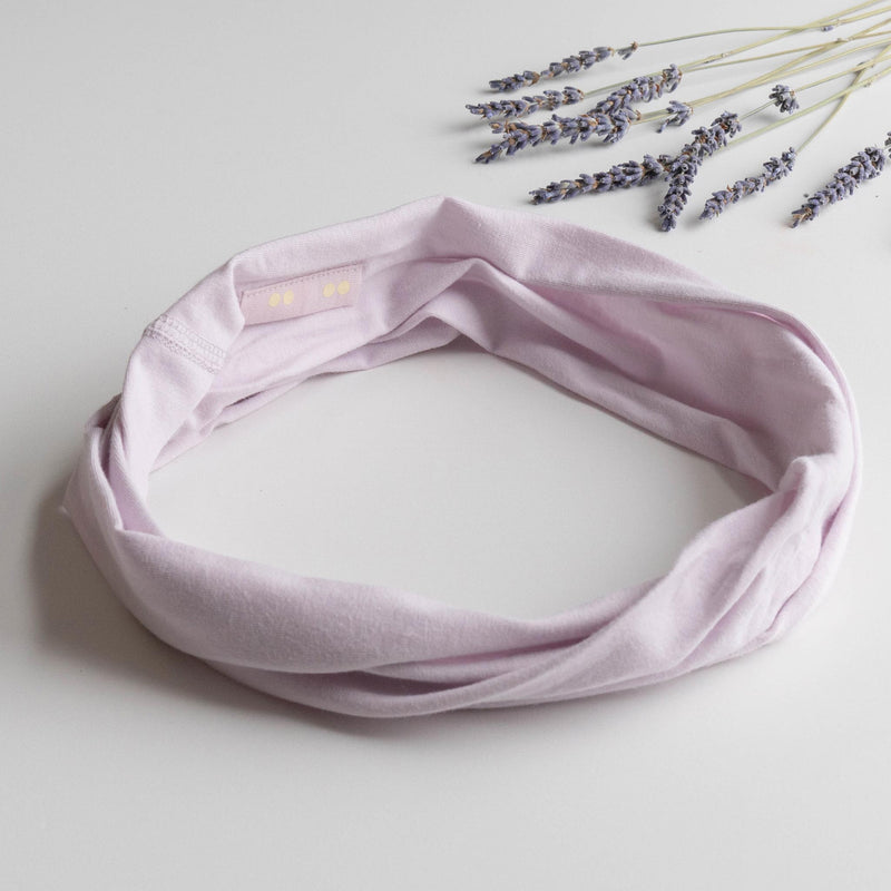 KOOSHOO organic twist headband in lavender glow. Flat lay with freshly picked lavender flowers #color_lavender-glow