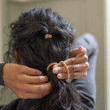 On Hair Image of KOOSHOO plastic-free round hair ties mondo 8 pack golden fibres	#color_golden-fibres-8-pack